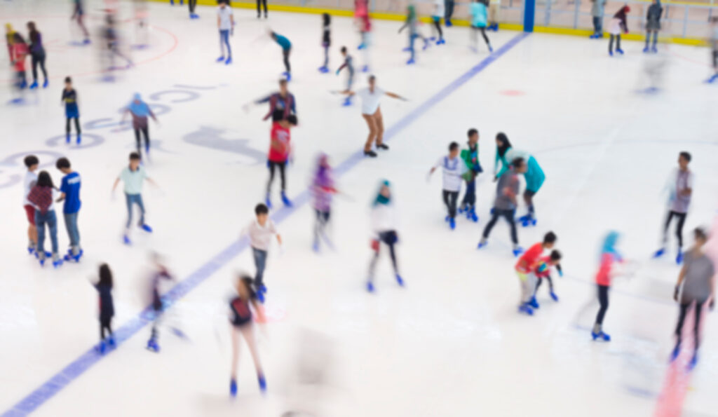 Defocused of indoor ice skating park with skating people.