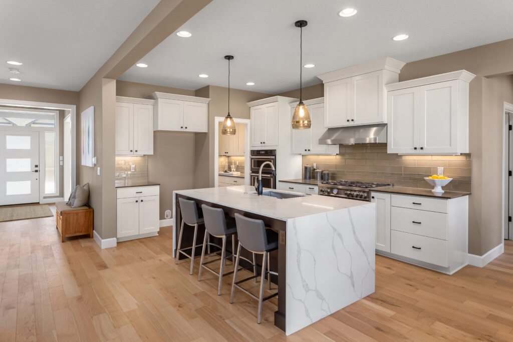 A bright open kitchen and front entry showing clear countertops and warm lighting for a 10-minute pre-showing checklist.