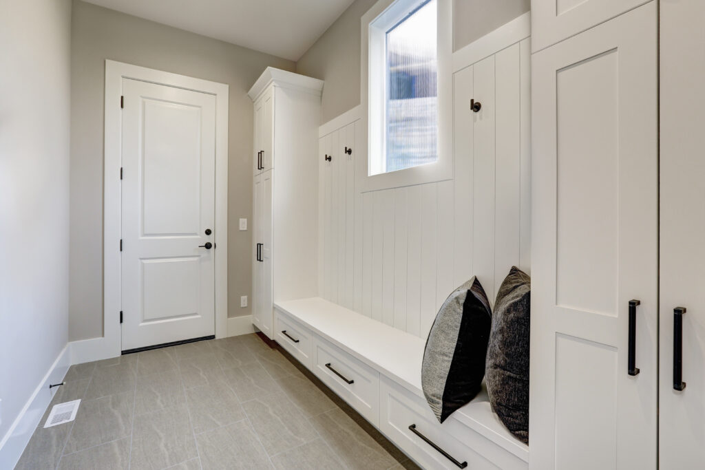 Clean organized white mudroom built-ins and entryway bench for back to school decluttering.