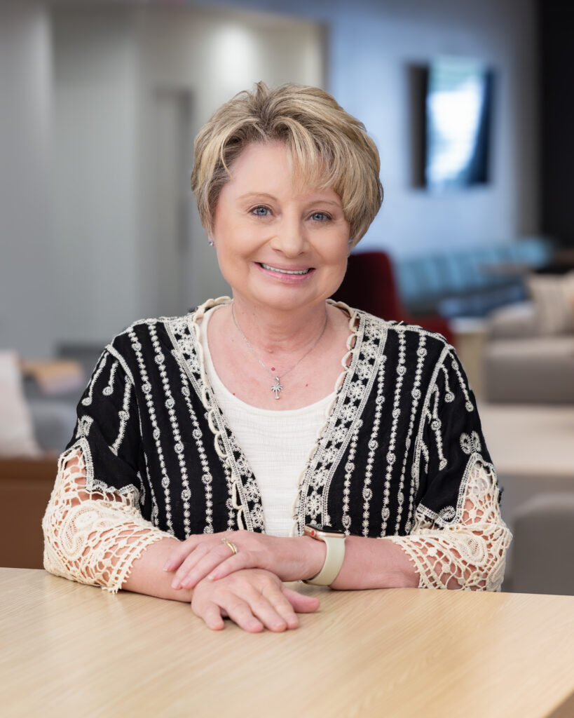 Professional headshot of REALTOR® Mindy Johnston smiling, representing Berkshire Hathaway HomeServices C. Dan Joyner, REALTORS®.