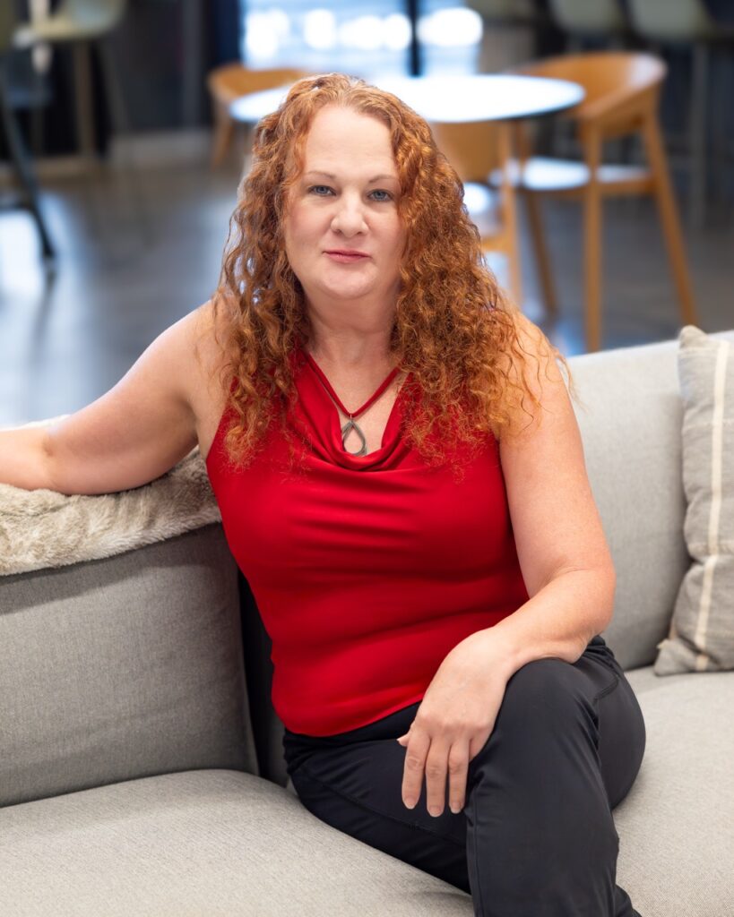 Professional headshot of REALTOR® Myra Gooding smiling in a red sleeveless top, a licensed agent at the Midtown office of Berkshire Hathaway HomeServices C. Dan Joyner, REALTORS®.